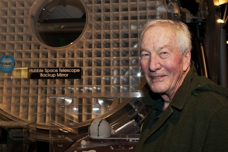 Photo of George T Keene standing next to the Hubble backup mirror at the Smithsonian.