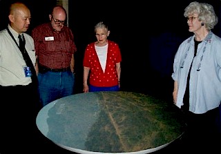 Photo of Photo of people viewing a projected image on the display table of the Griffith Observatory camera obscura built by George T. Keene.